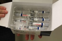 a white box of syringes containing a clear medication with a white and blue label wrapped around each